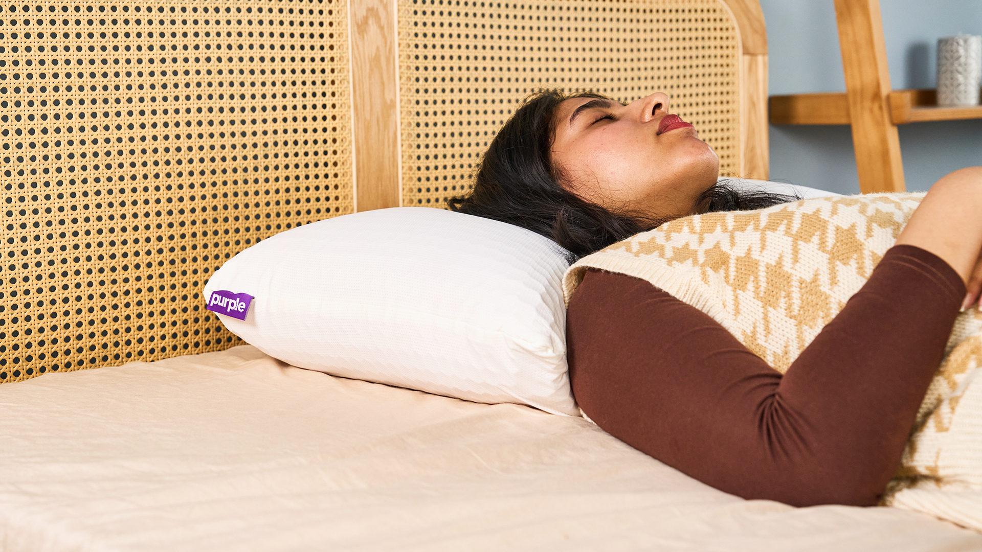 Γυναίκα που κοιμάται σε ένα λευκό μαξιλάρι με μια μωβ ετικέτα σε ένα κρεβάτι με ένα κεφαλάρι μπαστούνι