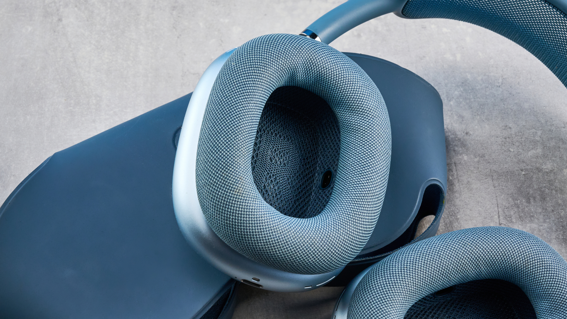 το airpods max (έκδοση 2024) σε μπλε χρώμα φωτογραφημένο με φόντο τον οδηγό του μπλε Τομ