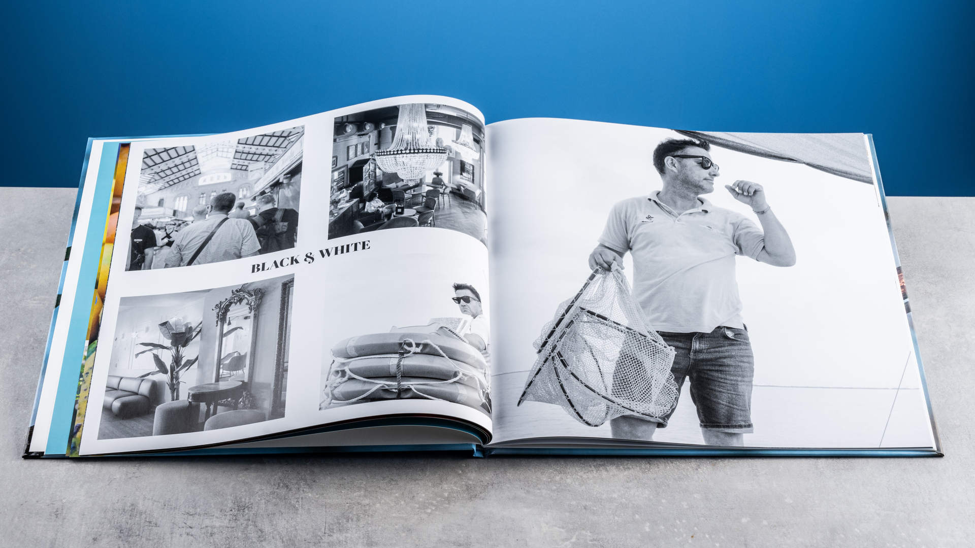 Σελίδες άλμπουμ φωτογραφιών Vistaprint φωτογραφημένες σε τραπέζι μπροστά σε μπλε φόντο