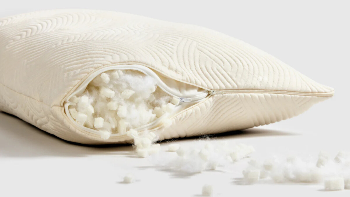 Ένα υπόλευκο μαξιλάρι άνοιξε μέχρι τη μέση με το γέμισμα από λάτεξ και ίνες να χύνονται έξω