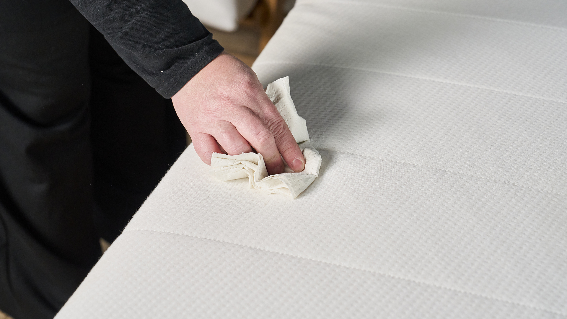 Μια γυναίκα που σκουπίζει ένα στρώμα με μια χαρτοπετσέτα