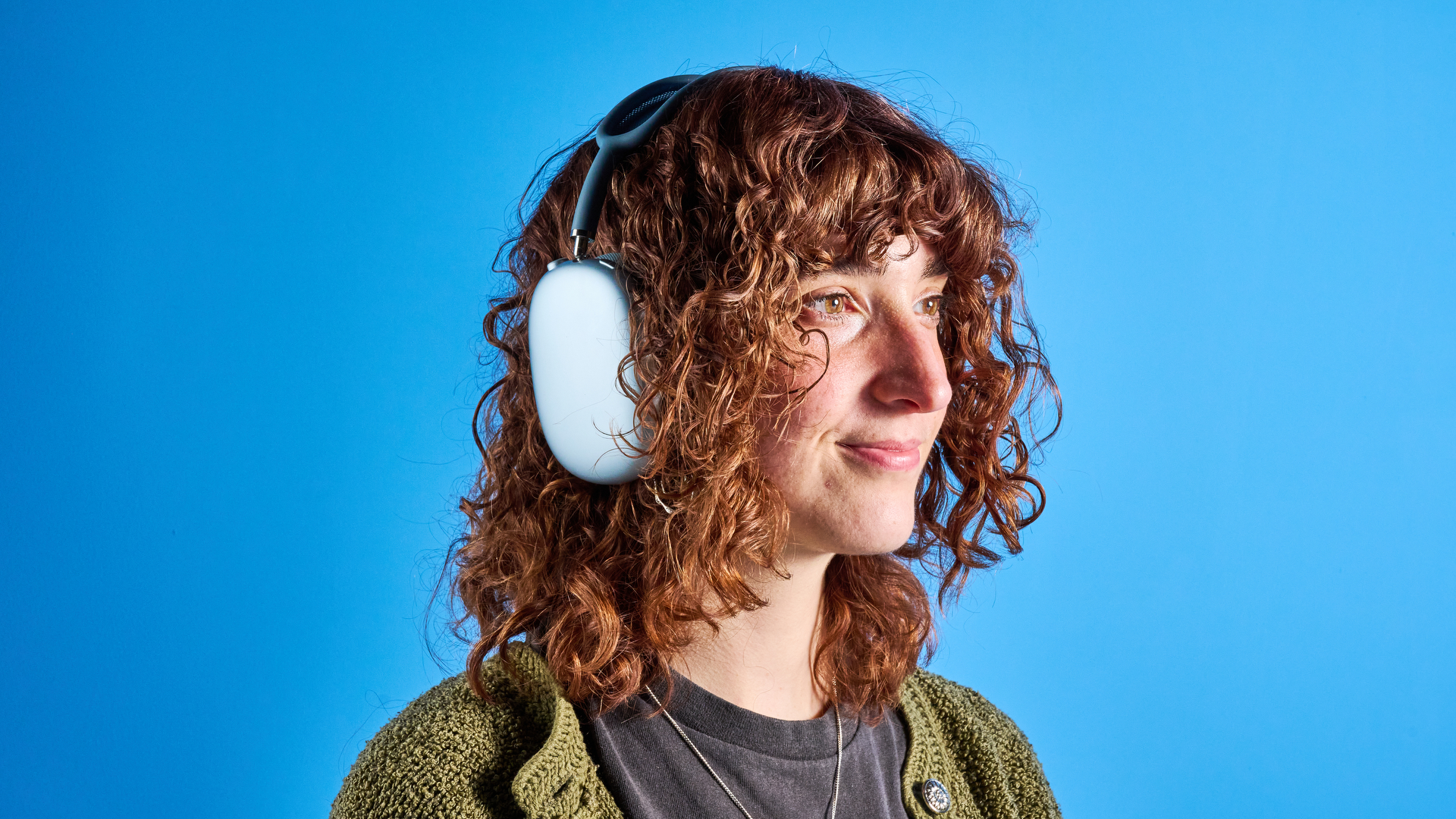 το airpods max (έκδοση 2024) σε μπλε χρώμα φωτογραφημένο με φόντο τον οδηγό του μπλε Τομ