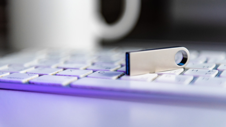 ασημί μονάδα flash τοποθετημένη σε λευκό πληκτρολόγιο