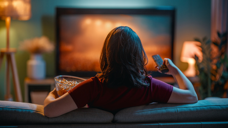 Άτομο που βλέπει τηλεόραση σε έναν καναπέ