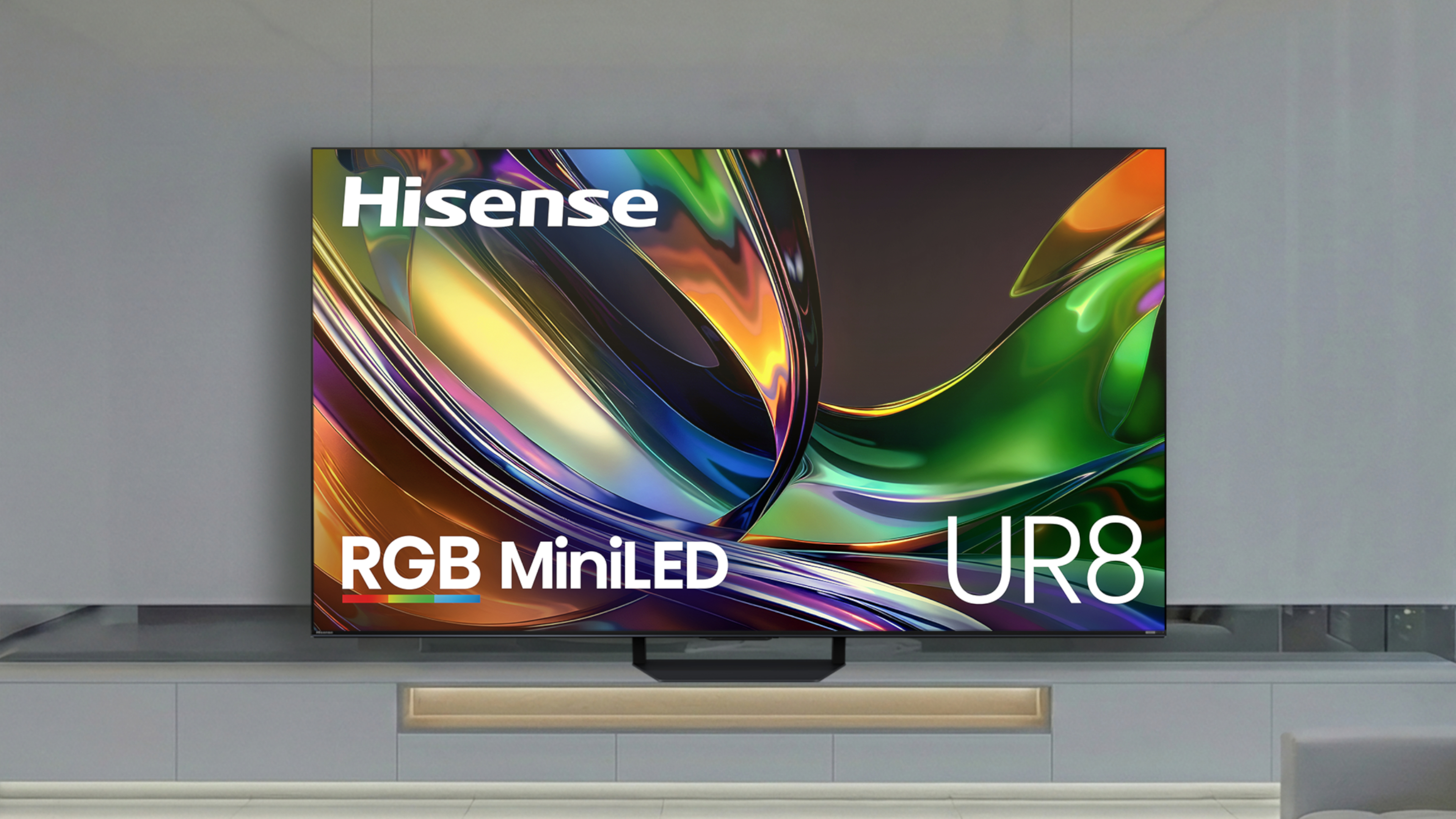 Η τηλεόραση Hisense UR8 RGB Mini-LED με πολύχρωμες, αφηρημένες εικόνες σε έναν μοντέρνο, μονόχρωμο χώρο διαβίωσης.