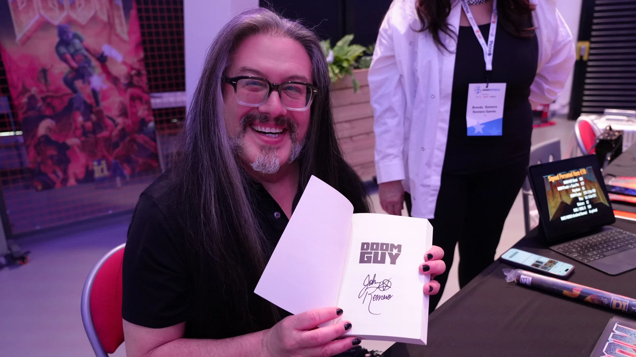 Ο Τζον Ρομέρο υπογράφει ένα αντίγραφο του βιβλίου του, Doom Guy.