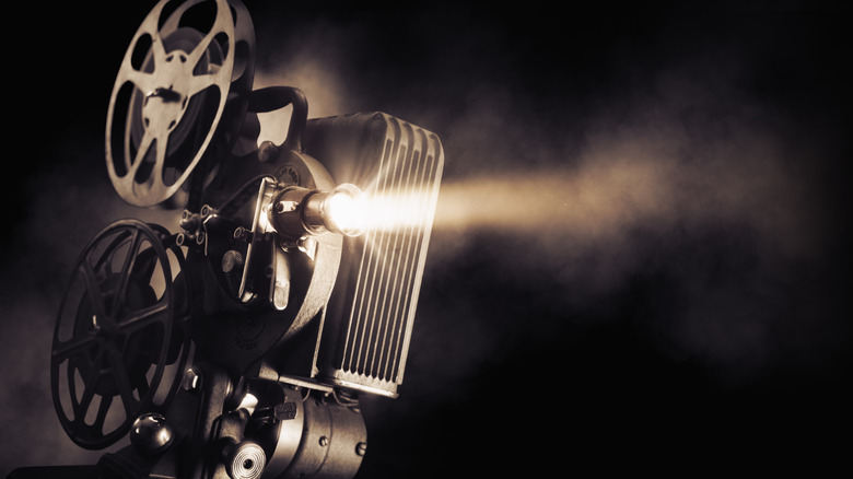 Μια κοντινή λήψη φωτός που εκπέμπει από έναν vintage προβολέα ταινιών με σκούρο φόντο.