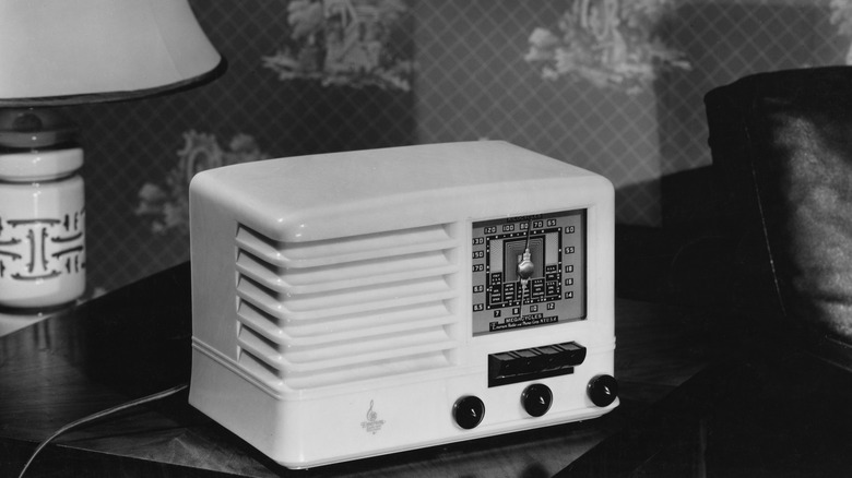 Ένα ραδιόφωνο με σωλήνα κενού Emerson σε ένα τραπέζι σε μια ασπρόμαυρη φωτογραφία.