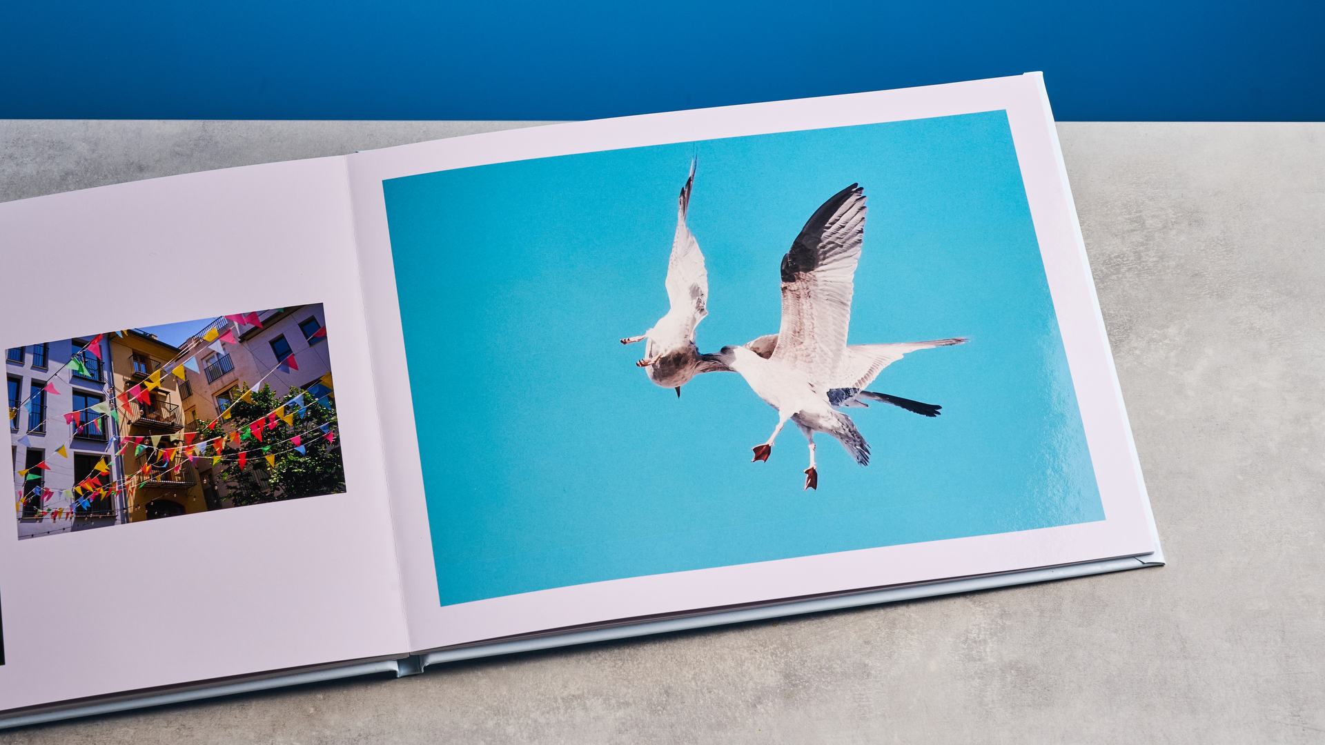 Το άλμπουμ φωτογραφιών Popsa φωτογραφίζεται μπροστά σε μπλε φόντο